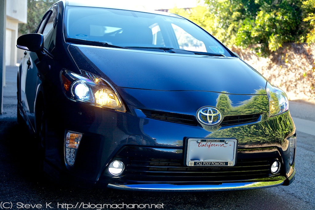 Quarter-side view of 2012 Toyota Prius ZVW30 with custom blacked-out headlights and custom DRL mod, custom foglights mod and low beams on